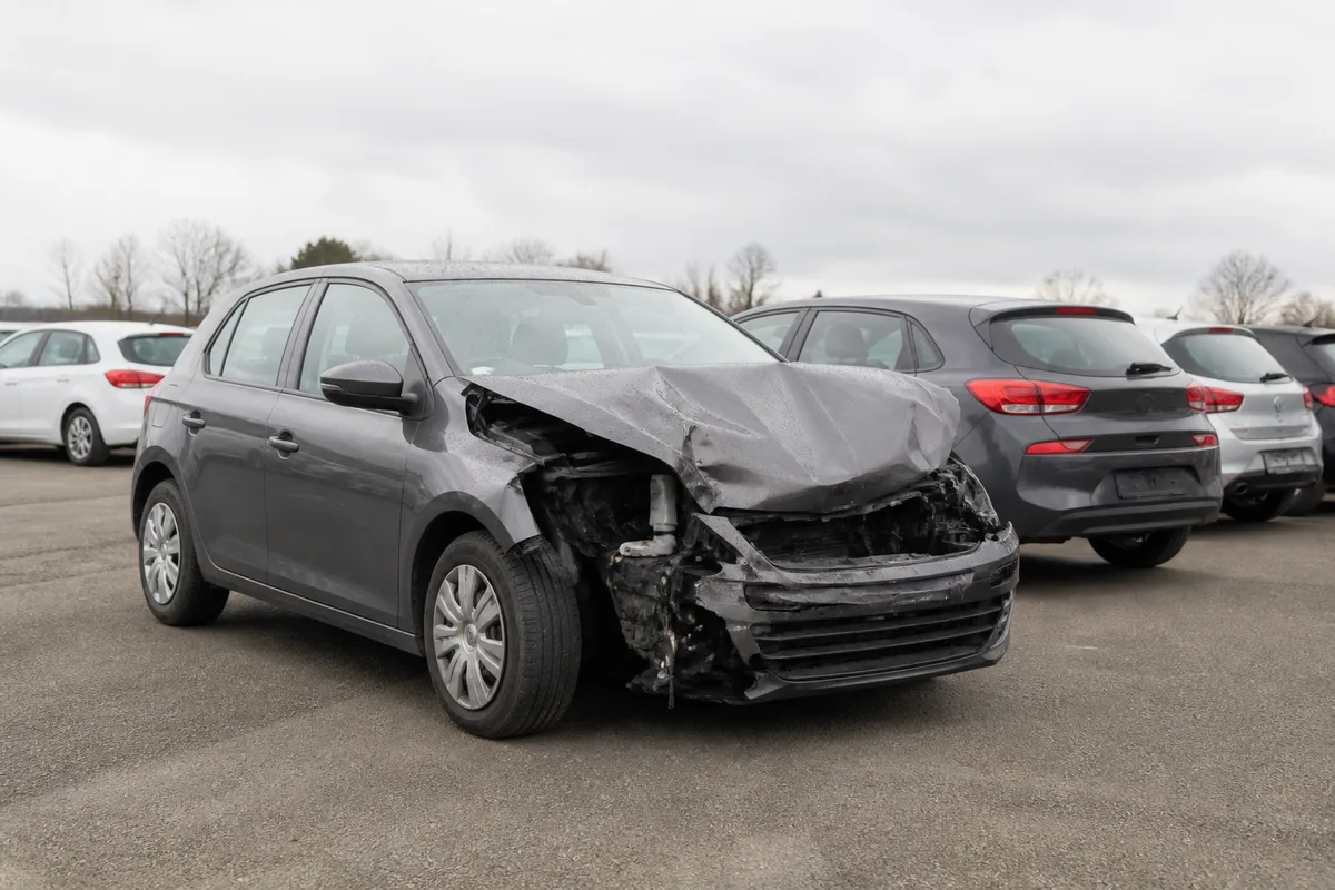 Voiture accidentée à l&rsquo;avant, capot déformé, sur une aire de stockage